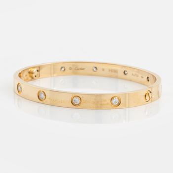 A Cartier "Love" bracelet in 18K gold set with ten round brilliant-cut diamonds.