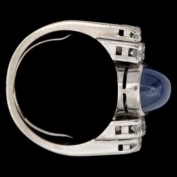 RING, cabochonslipad blå safir med briljantslipade diamanter, tot. ca 0.45 ct.
