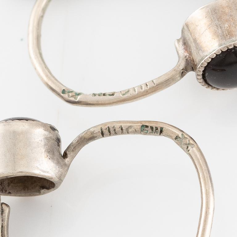 Örhängen silver med svarta stenar.
