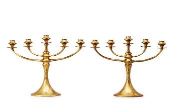 A pair of brass candelabra attributed to Bruno Paul, Germany, early 20th Century.