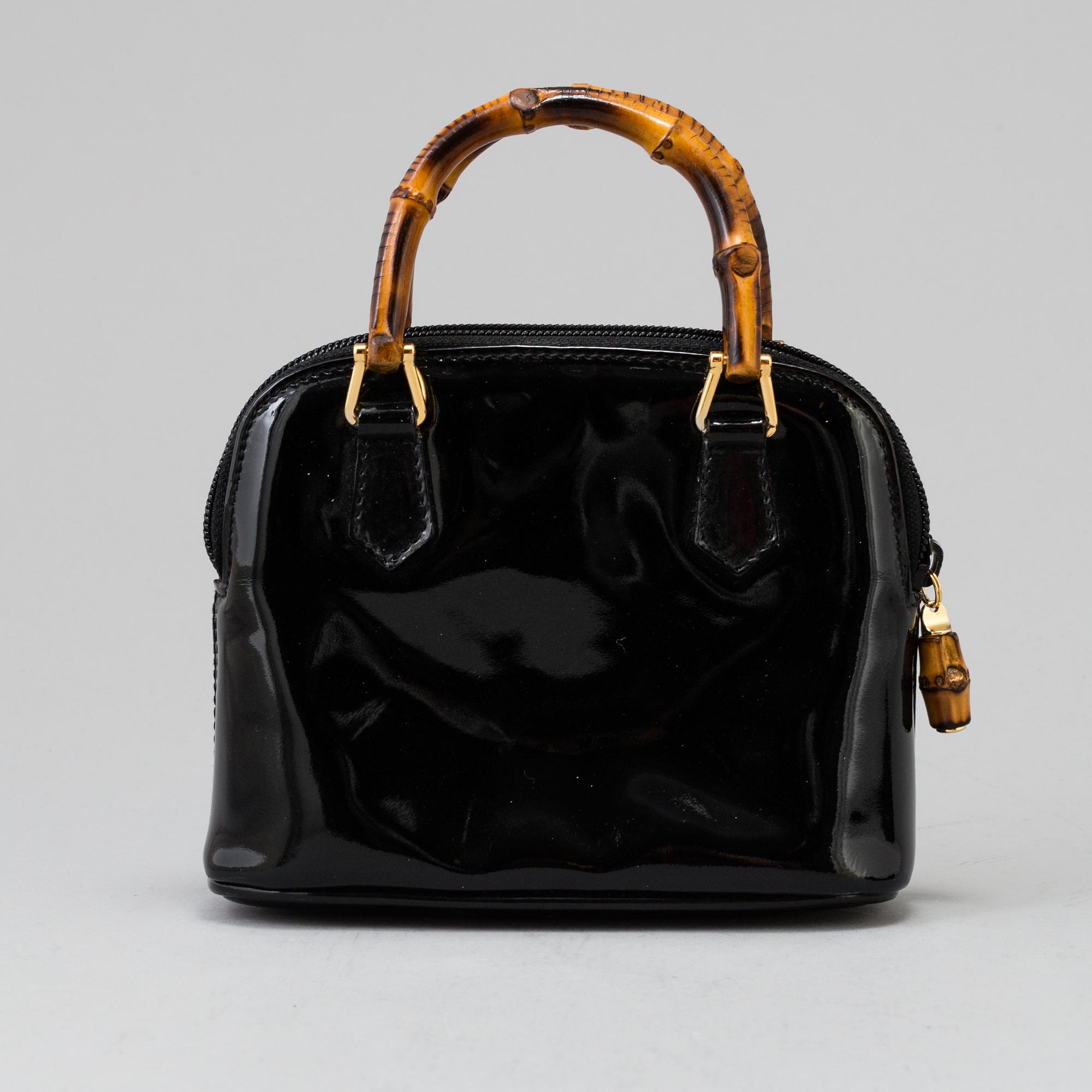 A Gucci patent leather bag with bamboo handle.