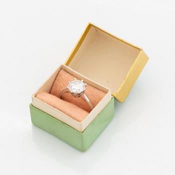 An 18K white gold ring set with a round brilliant-cut diamond.