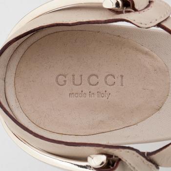 GUCCI, a pair of beige leather sandals.