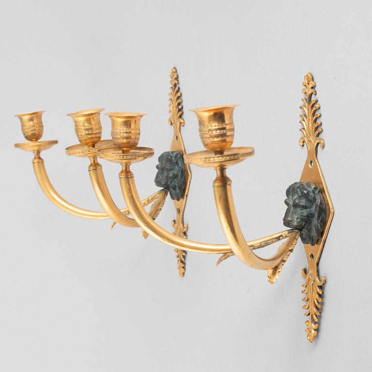 A pair of Empire-style two-branch patinated and gilt bronze appliques, 20th century incorporating older elements.