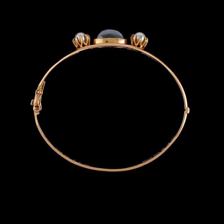 ARMRING, 18K guld med 2 odlade pärlor samt cabochonslipad hematit. Vikt 22,3 g.
