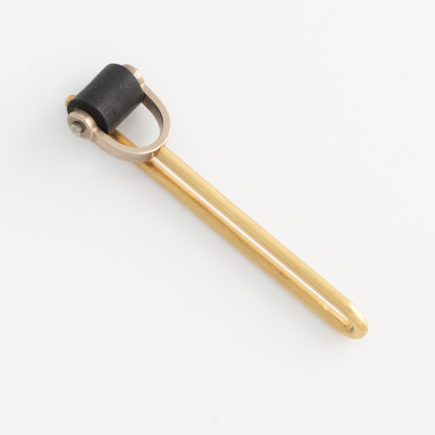 Glenn Roll, slipsnål, 18K guld, metall och svart gummi.