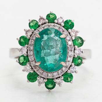 A 14K white gold ring with an emerald 2.40 ct, tsavorites 0.75 ct and diamonds ca 0.42 ct. With IGI certificate.