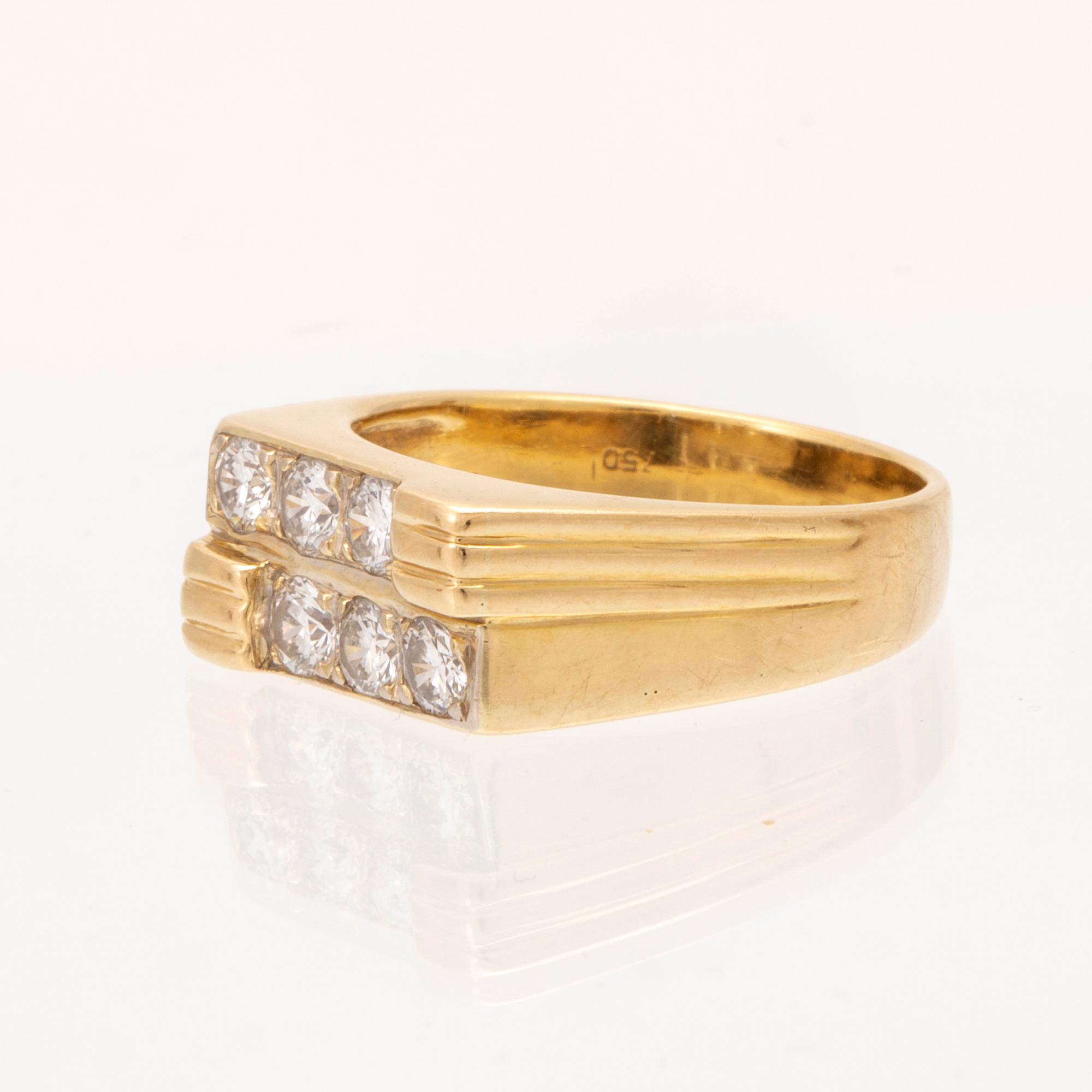 An 18K gold ring set with round brilliant cut diamonds.