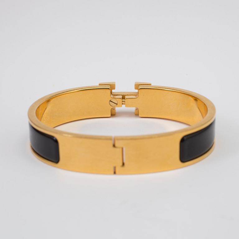 Black enamel and golden bracelet "Clic H" by Hermès.