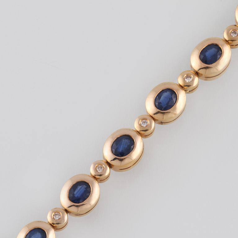 ARMLÄNK, 14K guld med 6 briljantslipade diamanter samt 7 fasettslipade blå safirer. Vikt 11,4 gram.