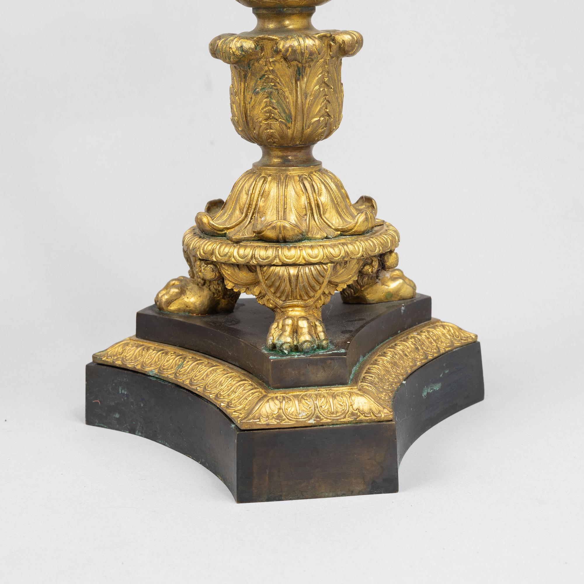 A pair of French Empire-style patinated and gilt bronze five-light candelabra, later part 19th century.