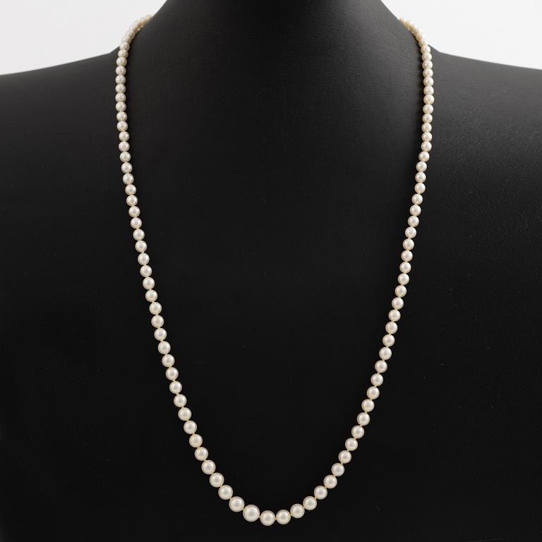 Necklace with graduated cultured pearls, with a clasp in 18K white gold set with an emerald.