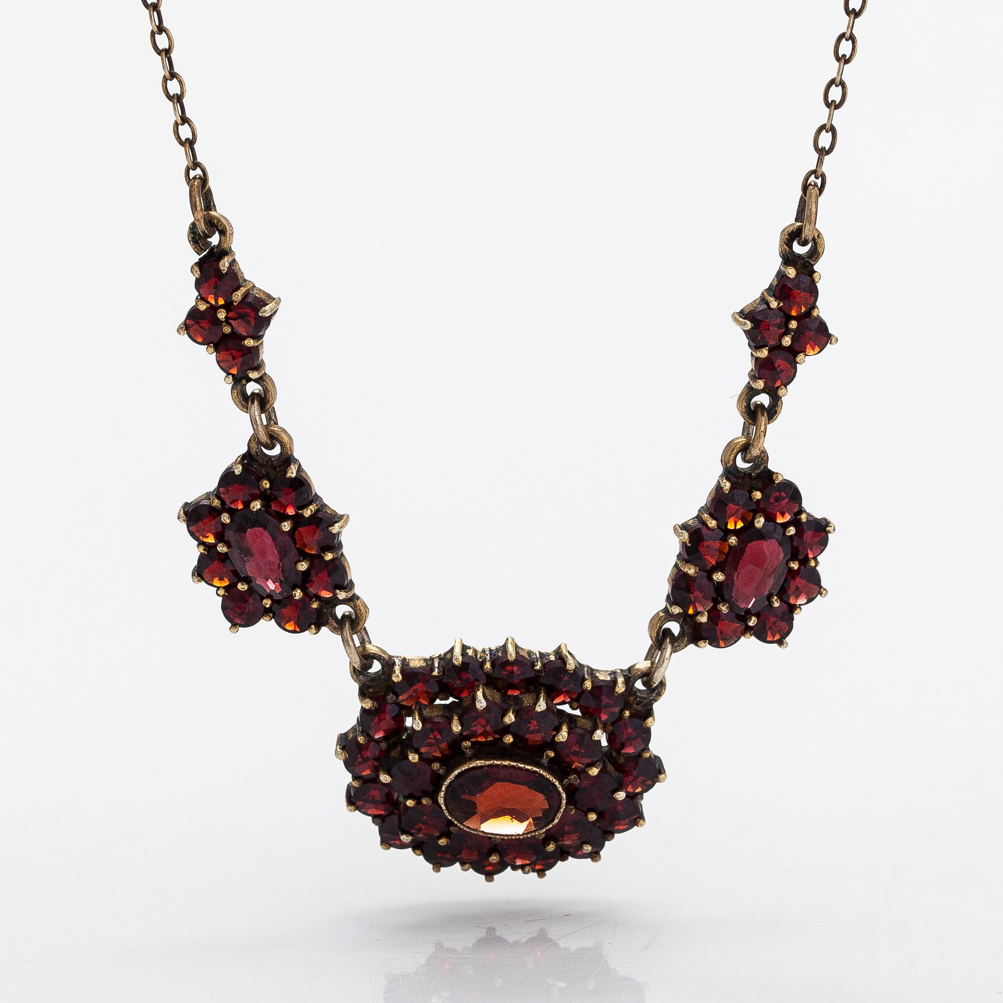 A necklace, brooch and earrings, gilded silver and garnets.