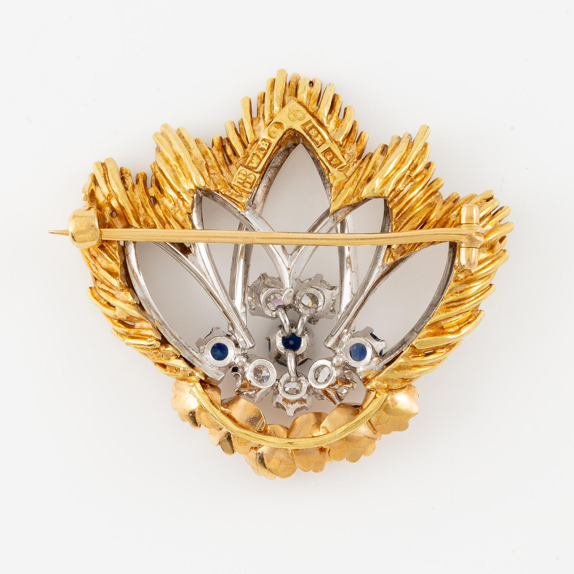 A W.A. Bolin brooch in 18K gold with round brilliant-cut diamonds and sapphires.