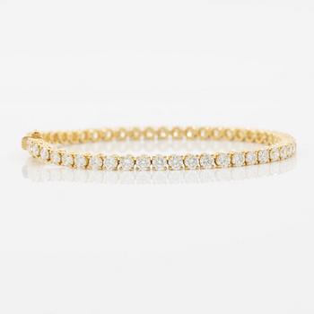Tennis bracelet in 18K gold with round brilliant-cut diamonds.