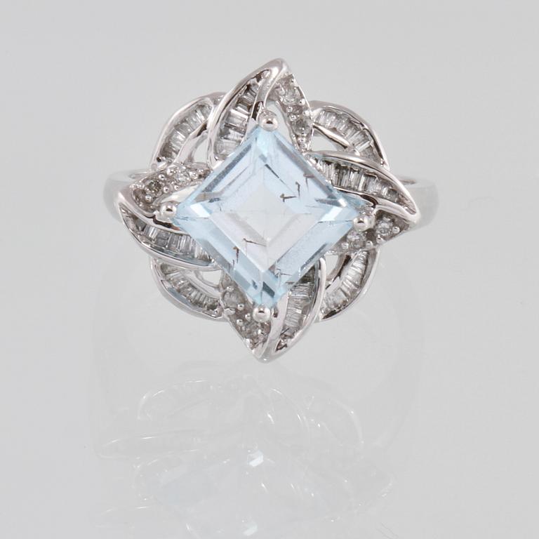 RING, 18K vitguld med carréslipad blå topas 4.07 ct samt baguett och briljantslipade diamanter 0.36 ct. Vikt 4,1 gram.