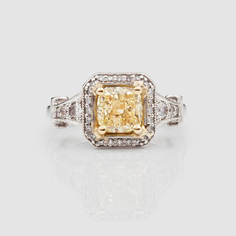 A 1.73 cts Fancy Yellow/VVS2 cushion-cut diamond ring, surrounded by colourless diamonds circa 0.80 cts in total.