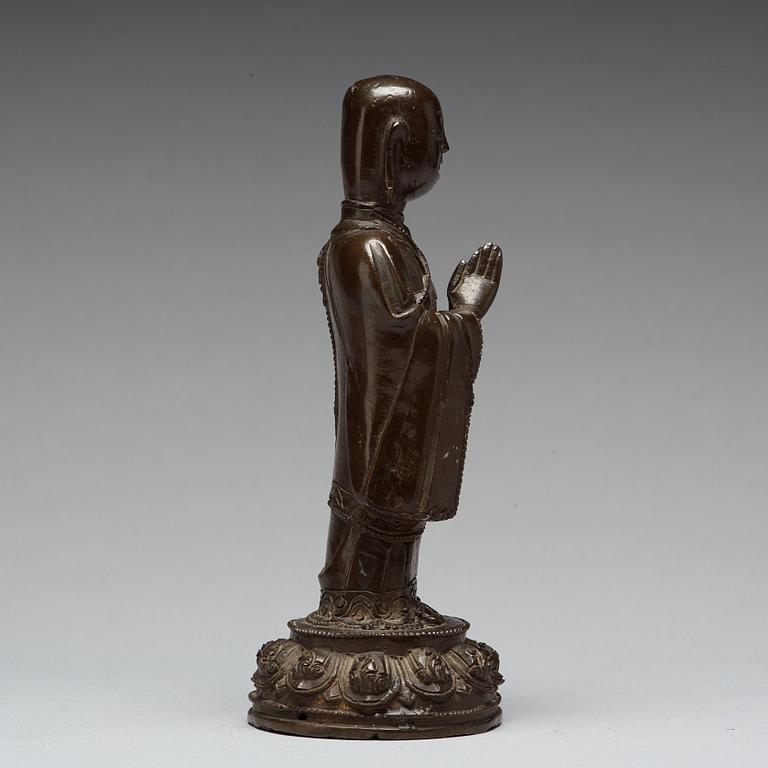 A bronze figure of a standing buddha, late Ming dynasty (1368-1644).