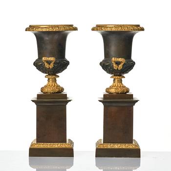 A pair of French Louis Philippe gilt and patinated bronze urns, first part 19th century.