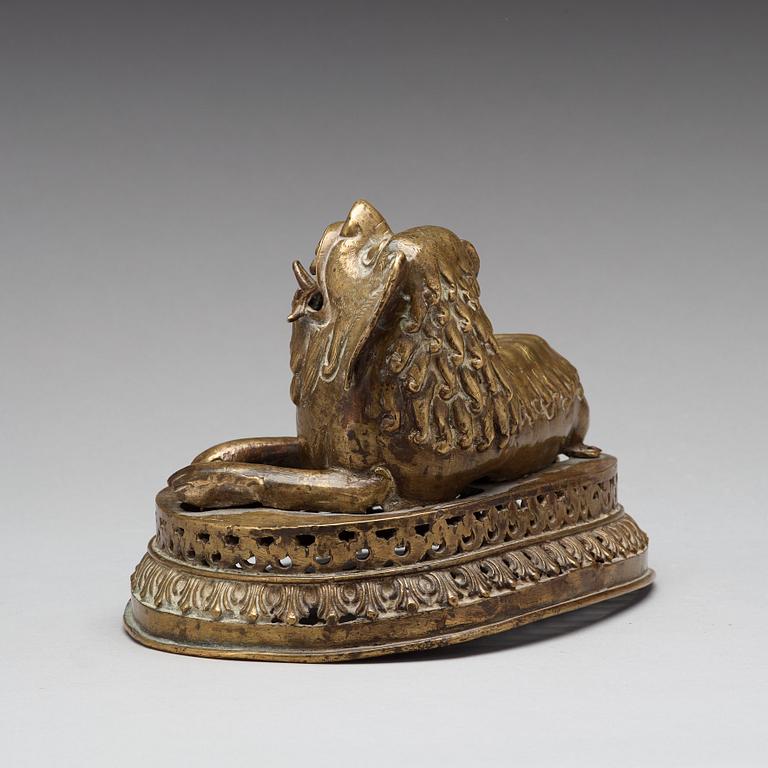 A copper alloy figure of a reclining buddhist lion, presumably 18th Century.