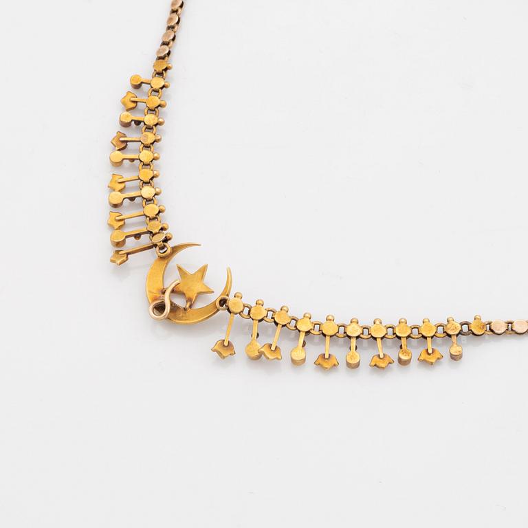 A gold necklace set with pearls.