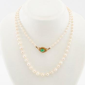 Necklace of cultured pearls with a clasp of 18K gold and cabochon-cut green stone.