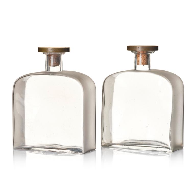 Firma Svenskt Tenn, a pair of glass bottles with pewter and brass stoppers designed by Björn Trägårdh, 1930s.