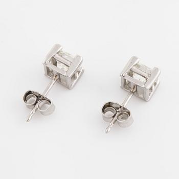 A pair of princess cut diamond earrings.