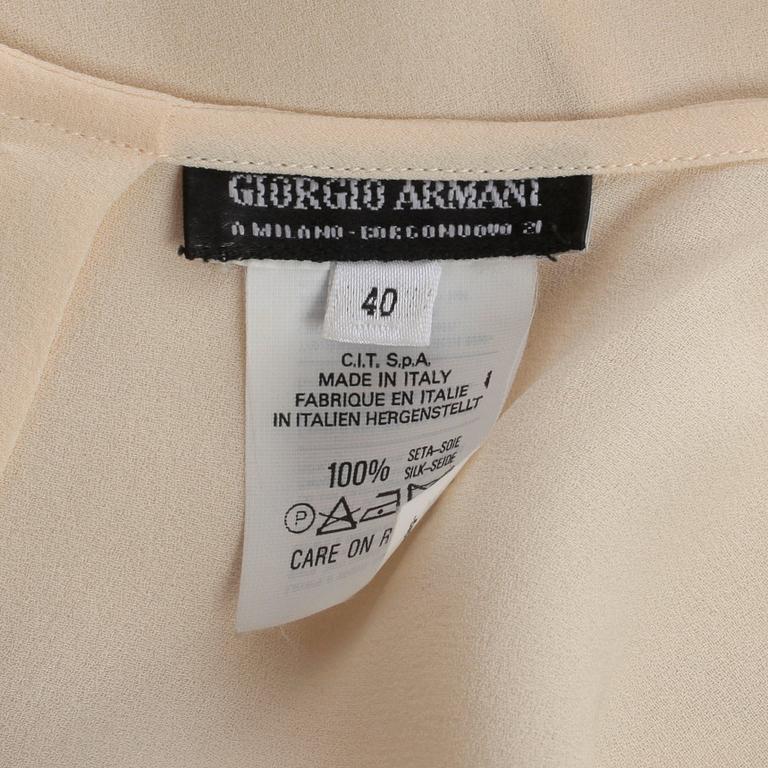 GIORGIO ARMANI, a light beige silk blouse.