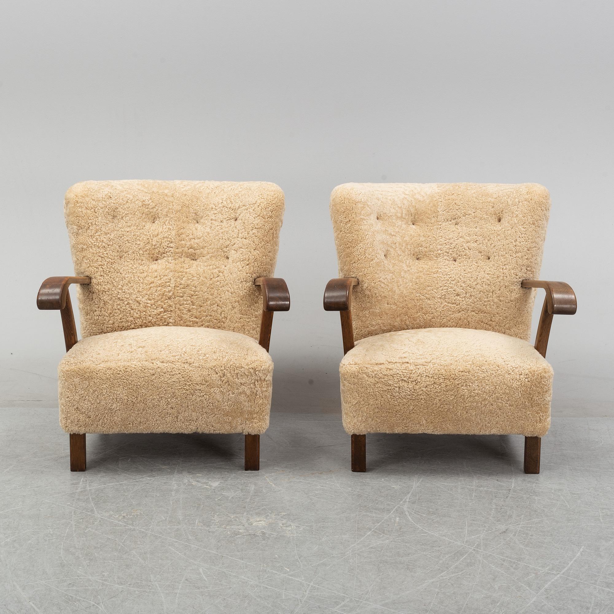 A pair of Danish lounge chairs with sheepskin upholstery.