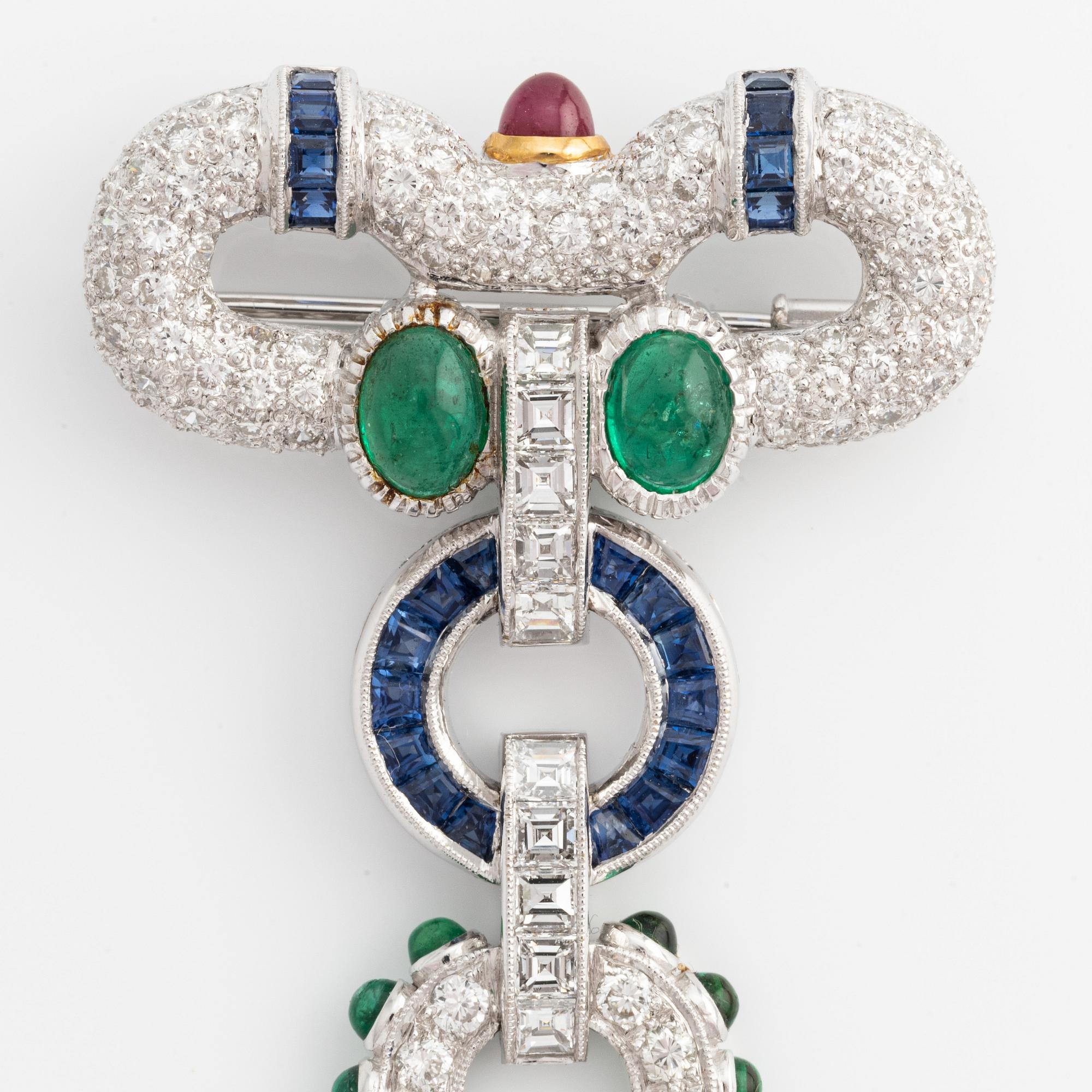 Brooch, white gold with cabochon-cut emeralds, rubies, sapphires, and brilliant- and square-cut diamonds.