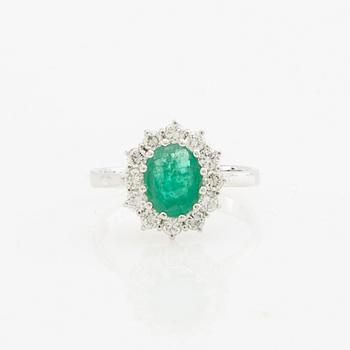 Ring 14K white gold set with an oval faceted emerald and round brilliant-cut diamonds.