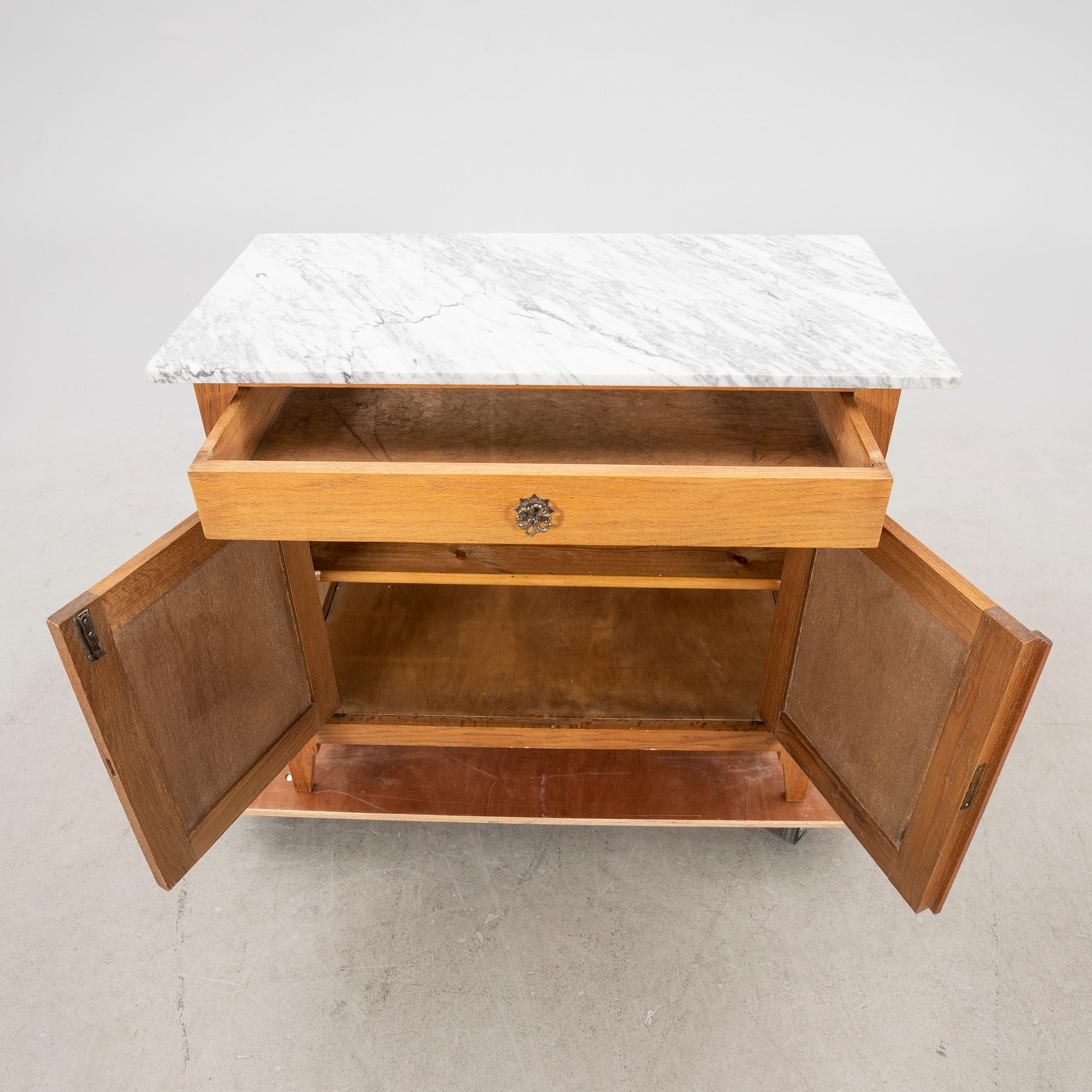 An early 1900s oak and marble cabinet.
