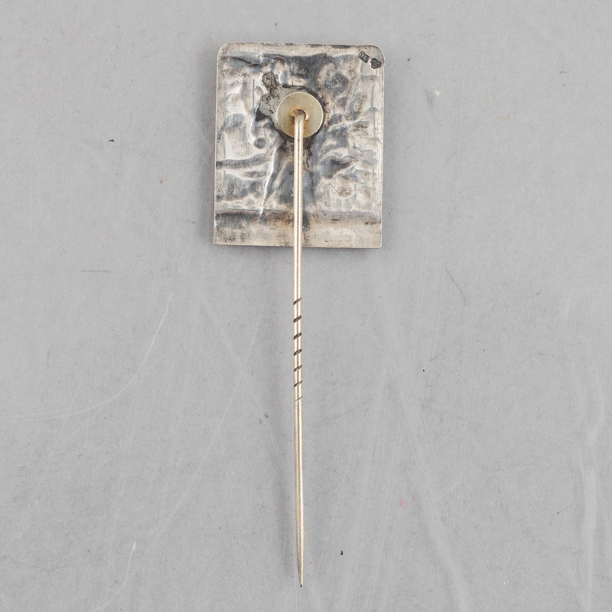A pair of candlesticks and a commemorative pin from the Olympic Games in Stockholm 1912.