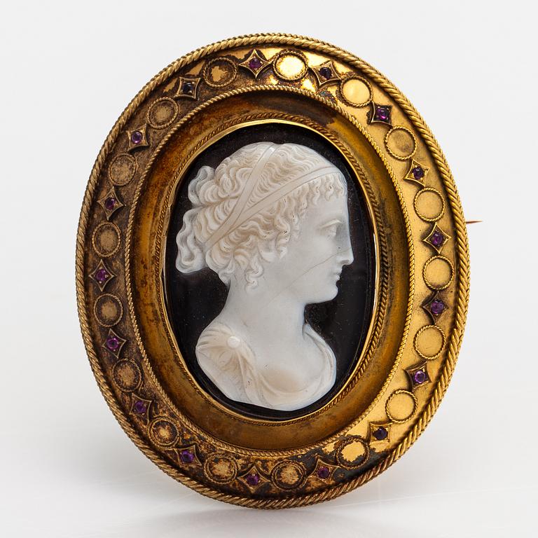 An 18K gold brooch with an onyx cameo and rubies.