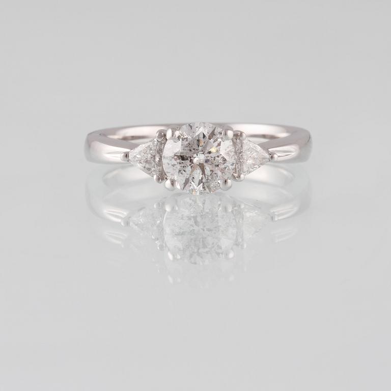 RING, 18K vitguld med briljantslipad diamant 1.03 ct samt 2 triangelslipade diamanter 0.17 ct. Vikt 4,4 gram.