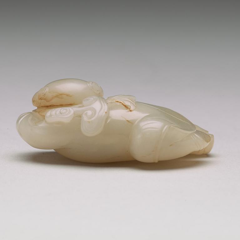 A nephrite figure of a reclining boy holding a lingzhi fungus, 20th Century.