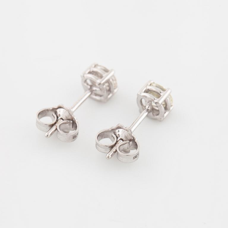 A pair of brilliant cut diamond earrings.