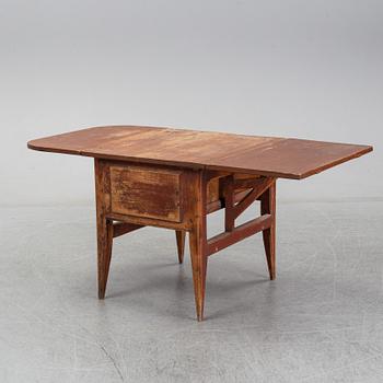 A 19th Century table with drop leaves.
