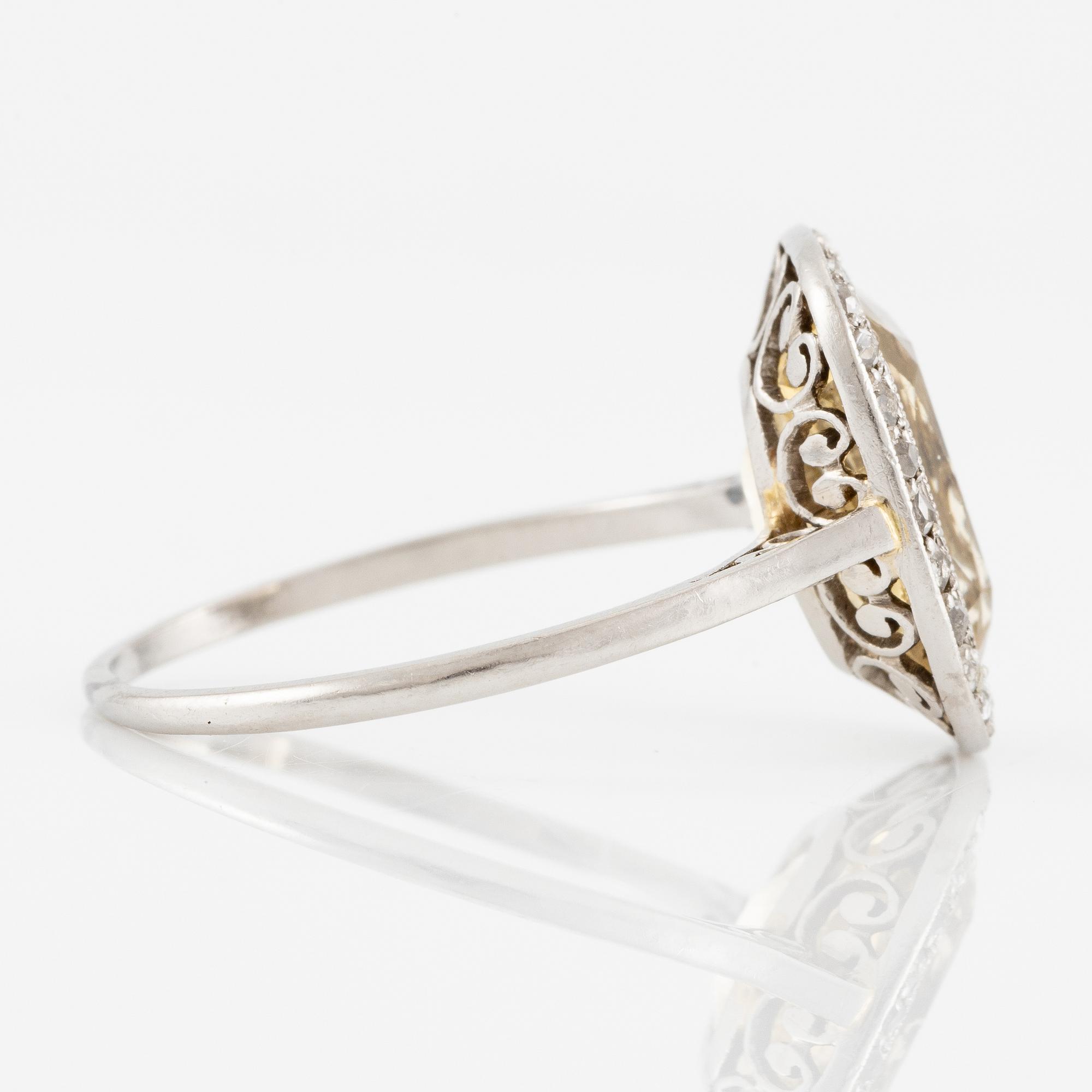 A ring in 18K white gold set with a yellow faceted tourmaline and rose-cut diamonds.