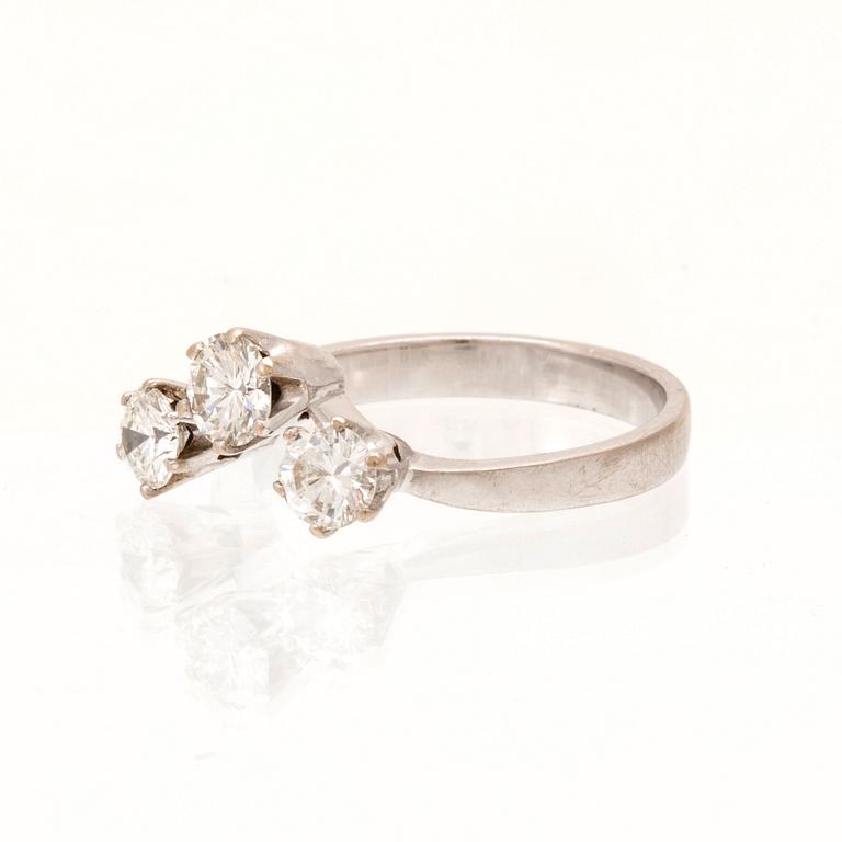 An 18K white gold ring/three stone ring set with round brilliant cut diamonds.
