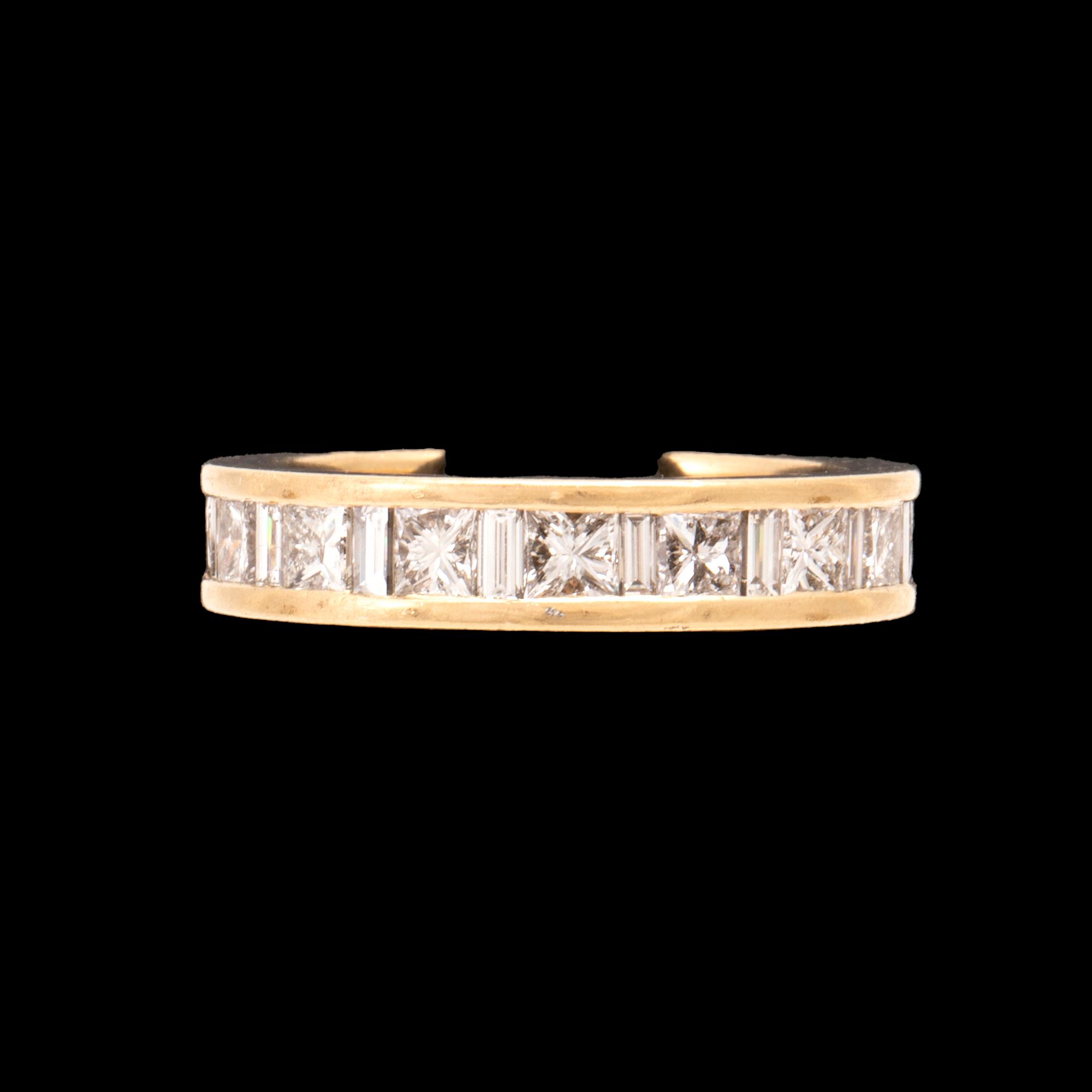 An 18K gold eternity ring set with baguette and princess cut diamonds by Hartmann's Denmark.