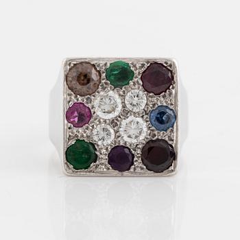 An 18K white gold ring set with round brilliant-cut diamonds and colored stones.