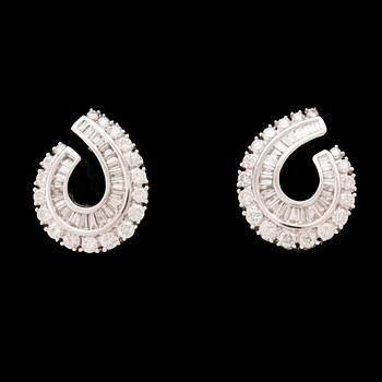 A pair of 18K white gold earrings set with round brilliant-cut and tapered baguette-cut diamonds.