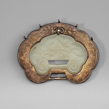 A carved nephrite clasp with silverplated mounting, late Qing dynasty (1664-1912).