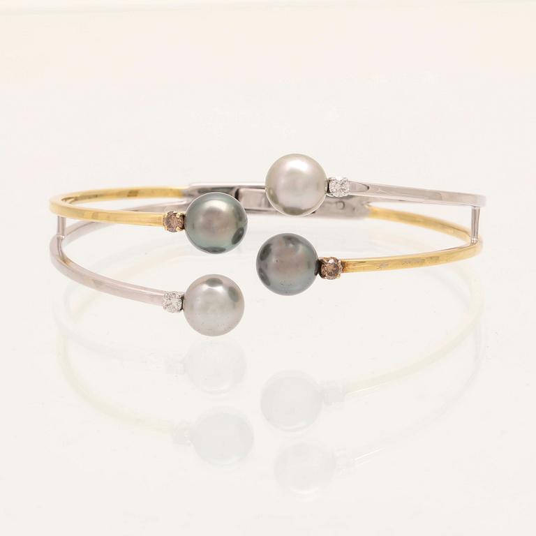 An 18K white- and yellow gold bracelet with round brilliant cut diamonds and cultured Tahitian pearls, Damiani Italy.