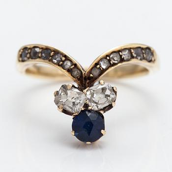 A 14K gold ring with a synthetic sapphire, radiant-cut diamonds ca. 0.28 ct in total and rose cut diamonds.