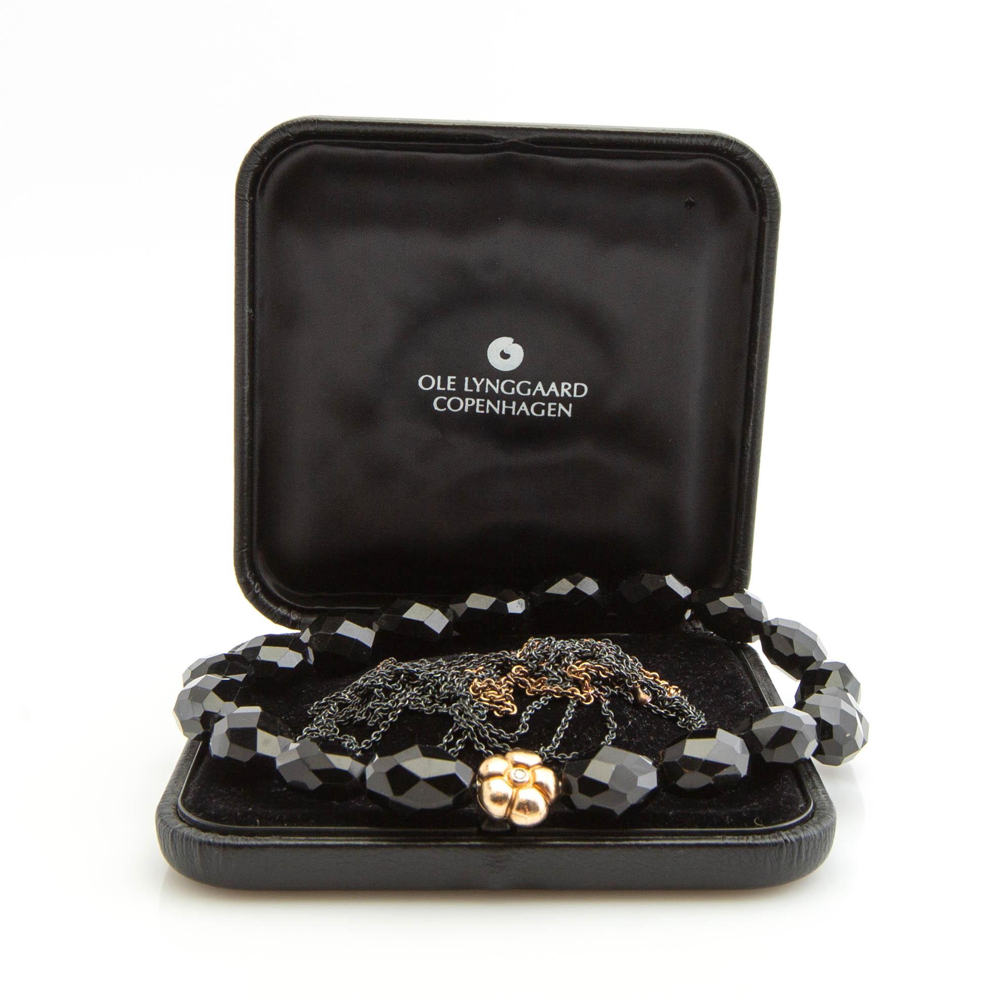 Ole Lynggaard, clasp, 18K gold with a round brilliant-cut diamond, and two necklaces.