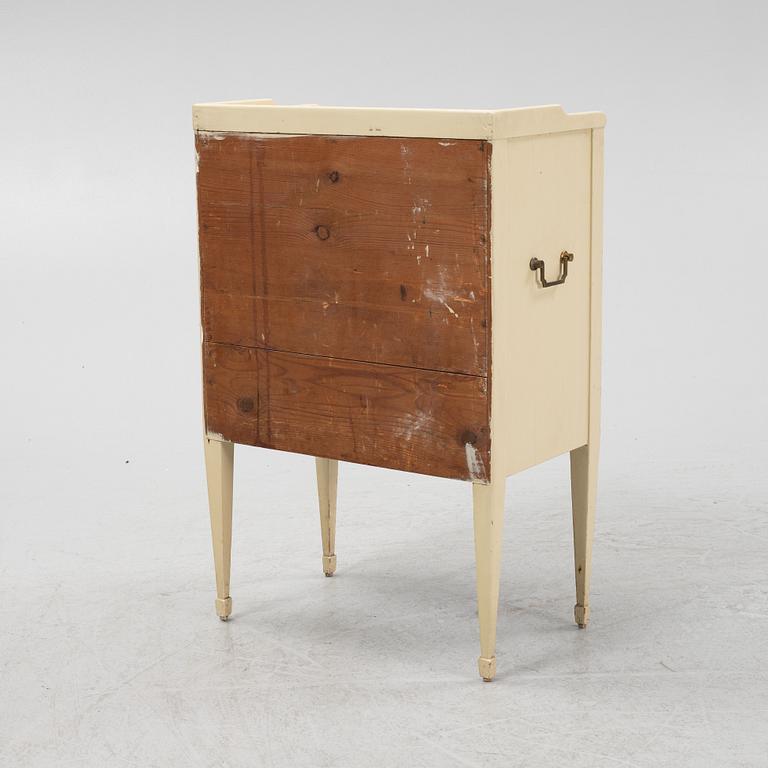 A Gustavian style painted bedside cabinet from around the year 1900.