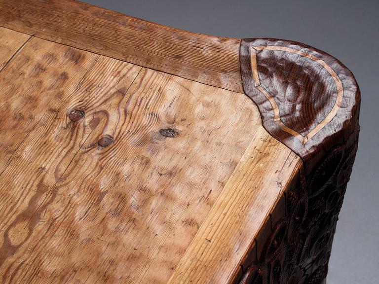 Gustaf Fjaestad, an Art Nouveau carved pine table, Arvika Sweden 1914, a double to the table in the Thiel Collection,